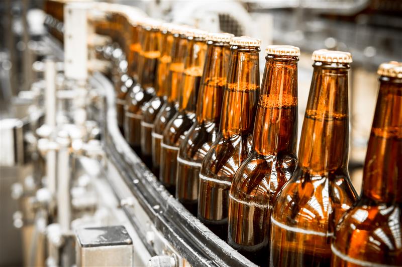 Brown glass bottles on an factory assembly line