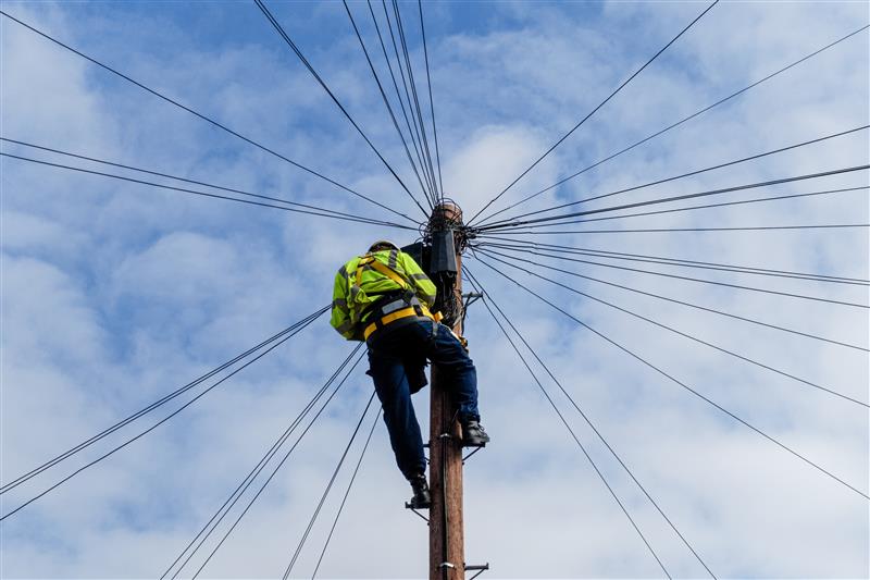 Electrician climbing a telephone pole