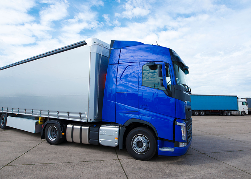 Blue tractor trailer delivery truck in a parking lot Blue tractor trailer delivery truck in a parking lot
